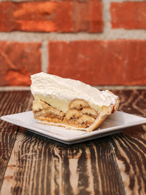 a creamy banana filling topped with whipped cream and a golden pie crust