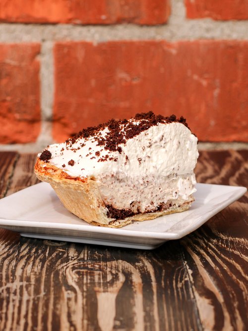 A creamy cream cheese base, topped with luxurious whipped cream, and adorned with homemade Oreos.