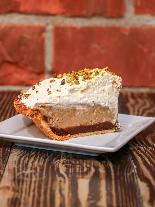 A scrumptious slice of Earl Grey pie delicately placed on a plate, sitting atop a charming wooden table.