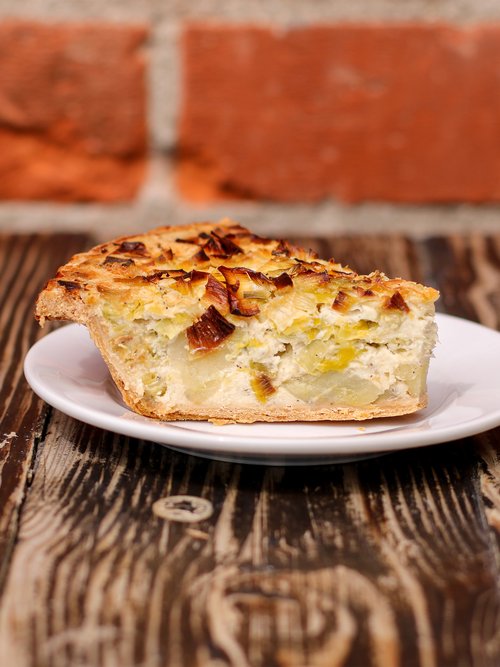 A scrumptious slice of spinach mushroom quiche elegantly presented on a plate, awaiting enjoyment.