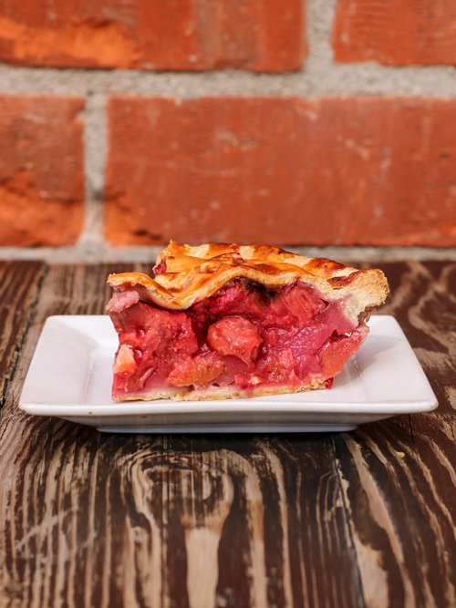 The sweet temptation of a slice of sugary strawberry rhubarb pie, served on a pristine white plate - a perfect for any occasion!