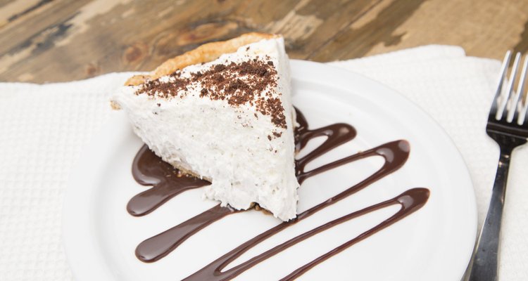 A slice of cream pie with chocolate drizzle.