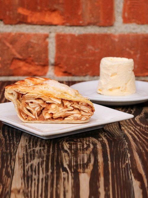 A delicious slice of apple pie with a side of creamy ice cream. The perfect dessert combo from Republic of Pie.