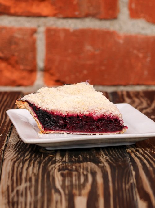 A delectable marionberry pie crafted with a delightful blend of raspberries and blackberries, nestled in a crust that's simply irresistible. 
