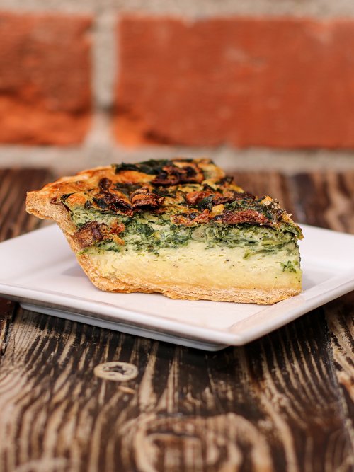 Yummy spinach mushroom quiche slice served on plate. Get it at Republic of Pie.