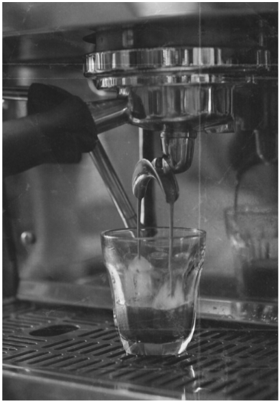 A vintage espresso machine in black and white. The spill of coffee beans that 